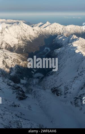 Aus der Vogelperspektive über die südlichen Alpen mit Blick auf den La Perouse Gletscher, der in Richtung Tasmansee im fernen Hintergrund fließt. Stockfoto