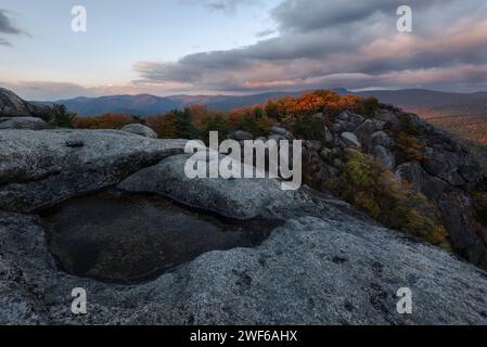 Rotes Sonnenaufgangslicht küsst den Gipfel des Old Rag Mountain an einem frischen Herbstmorgen, während sich im Hintergrund die Wolken über dem Skyline Drive erheben. Stockfoto