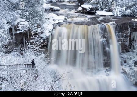 Ein Mann posiert auf der Aussichtsplattform vor den Blackwater Falls an einem Wintertag in Davis, West Virginia. Stockfoto