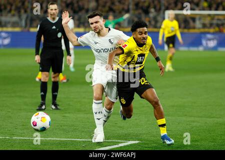 Dortmund, Deutschland. Januar 2024. Ian Maatsen (R) von Borussia Dortmund streitet mit Kevin Stoeger vom VfL Bochum während des ersten Ligaspiels zwischen Borussia Dortmund und VfL Bochum am 28. Januar 2024 in Dortmund. Quelle: Joachim Bywaletz/Xinhua/Alamy Live News Stockfoto