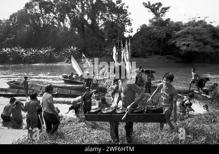 West Kalimantan, Indonesien. März 2007. Ein Mann wirft ein Gamelan-Schlaginstrument aus, während er an einer Menschenmenge vorbeiläuft – der Dayak Tamambaloh Community – die sich als reinigenden Akt mit Wasser überspritzt. vor einem Boot, das gerade die Familie ihres neuen traditionellen Häuptlings für einen Besuch der Grabstätte ihres ehemaligen Häuptlings in Sungai Uluk Palin (Sungulo Palin) Dorf, Putusibau Utara, Kapuas Hulu, West Kalimantan, Indonesien, transportiert hat. Kultur ist nach Ansicht der Vereinten Nationen ein unverzichtbarer Bestandteil jeder Entwicklung, wenn sie nachhaltig sein soll. Stockfoto