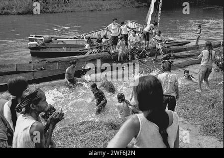 West Kalimantan, Indonesien. März 2007. Die Menschen spritzen sich gegenseitig mit Wasser, ein reinigender Akt, als ein Boot mit der Familie des neuen traditionellen Anführers der Dayak Tamambaloh Longhouse Gemeinschaft ankommt, nach einem Besuch eines nahe gelegenen Friedhofs, auf dem der ehemalige Häuptling begraben ist, im Dorf Sungai Uluk Palin (Sungulo Palin), Putusibau Utara, Kapuas Hulu, West Kalimantan, Indonesien. Kultur ist ein unverzichtbarer Bestandteil jeder Entwicklung, wenn sie nachhaltig sein soll, und es ist nach Ansicht der Vereinten Nationen von entscheidender Bedeutung, dass jeder Mensch und jede Gemeinschaft ihre kulturellen Rechte frei ausüben kann. Stockfoto