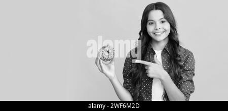 Happy Kid zeigt Finger auf süßen glasierten Donut, Essen. Stockfoto