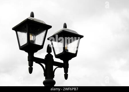 Schwarze rustikale Laterne vor grauem bewölktem Himmel. Stockfoto