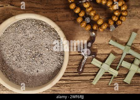 Rosenkranz-, Asche- und Palmblattkreuze auf Holztisch. Palm Sunday Konzept. Ash wednesday-Konzept Stockfoto