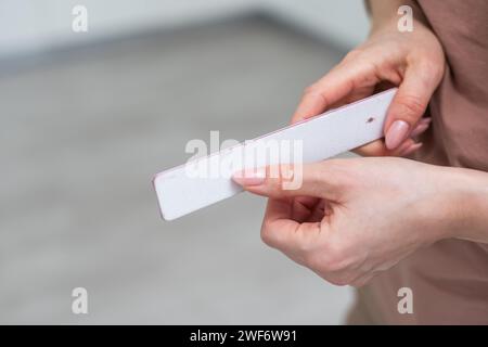 Maniküre- und Pedikürenfeile in einer Hand isoliert auf weißem Hintergrund. Kosmetisches Werkzeug Stockfoto