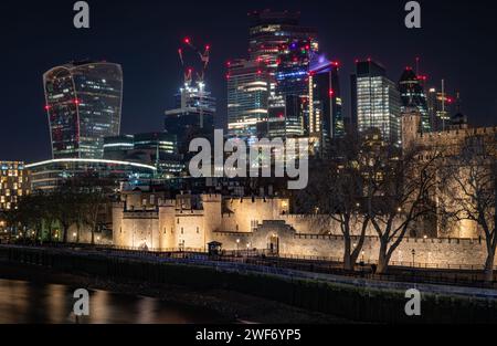 London. UK-01.27.2024. Der Tower of London bei Nacht mit Wolkenkratzern in der City of London im Hintergrund. Nachtsicht Langzeitbelichtung. Stockfoto