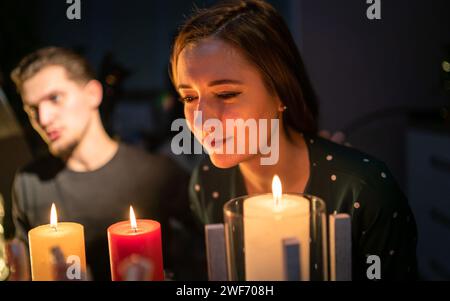Die Frau steht fasziniert von den Kerzen vor Guy Stockfoto