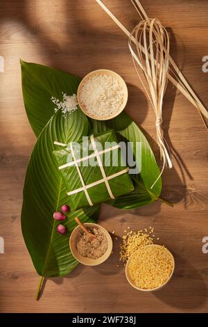 Schüsseln mit weißem Reis und gelben Mungbohnen und Holzformen, die für die Zubereitung von klebrigen Reiskuchen für die Tet-Feiertage vorbereitet sind. Traditionelles Mondlicht neu Stockfoto