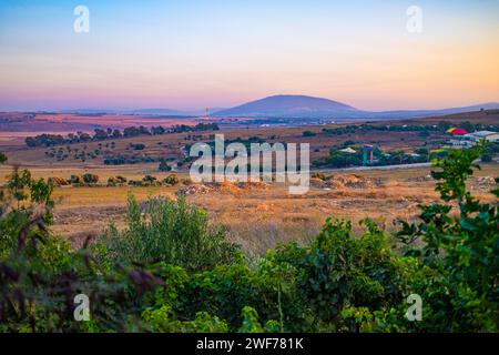 Die sanften Hügel des Unteren Galiläa bei Sonnenuntergang mit dem historischen Berg Tabor in der Ferne, der Israels natürliche Schönheit zeigt. Stockfoto