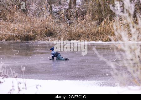 Ein Kind auf einem gefrorenen See im Winter ist riskant und lebensbedrohlich, Riedstadt, 18. Dezember 2022 Stockfoto