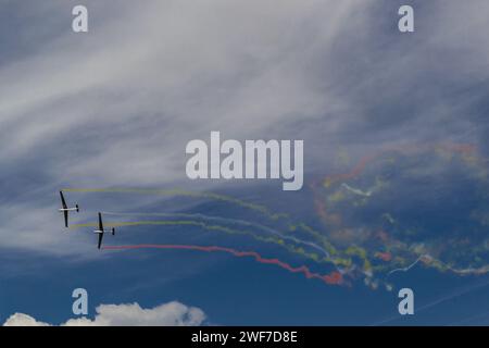 Zwei Flugzeuge hinterlassen farbige Rauchstreifen hinter sich am Himmel Stockfoto