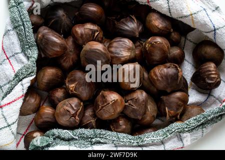 Ein Haufen heißer, gerösteter Kastanien, in ein Handtuch gewickelt Stockfoto