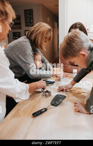Drei Generationen schneiden Zuckerkekse aus, Küchengenuss Stockfoto