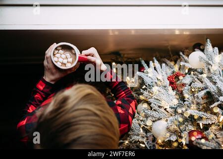 Blick von oben auf das Kind mit heißer Schokolade neben weihnachten t Stockfoto