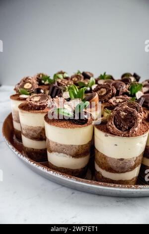 Tiramisu-Tassen auf einer Platte mit Schokoladendekorationen Stockfoto