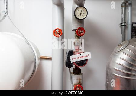 Warmwasserleitungen im Haus mit der Meldung „außer Betrieb“ Stockfoto