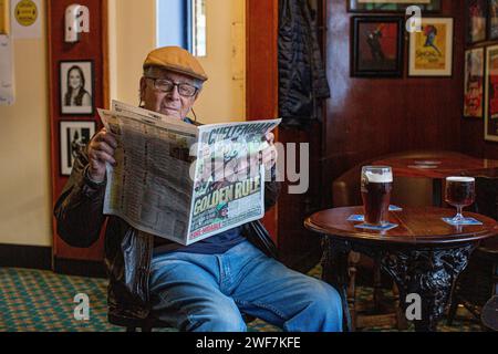 Reifer Mann liest Rennzeitung im Shakespeares Head Pub, Arlington Way, London, Großbritannien Stockfoto