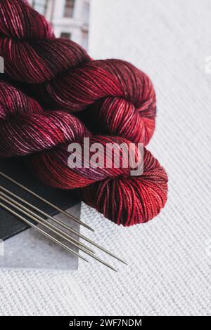 Knäuel aus Wollgarn und Nadeln zum Handstricken. Konzept für Handarbeit. Platz für Text. Stockfoto