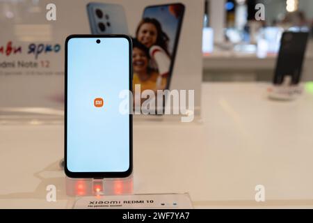 Xiaomi-Smartphone mit Xiaomi-Logo auf dem Bildschirm wird auf dem Display im Xiaomi-Geschäft gezeigt. Minsk, Weißrussland - 26. Januar 2024 Stockfoto