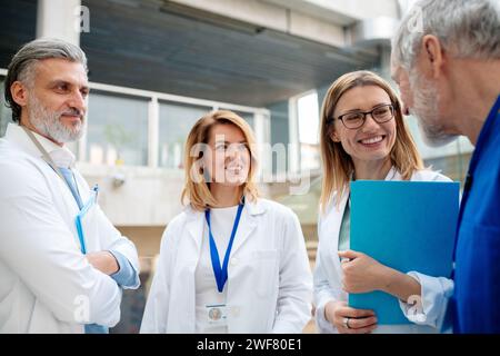 Ärzteteam, das in den Krankenhausflur geht. Kollegen, Ärzteteam diskutieren die Patientendiagnose. Stockfoto