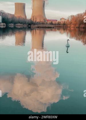 Täuschende Idylle am Meer mit einem Schwan vor dem Kernkraftwerk in den französischen Gemeinden Cruas und Meysse Stockfoto