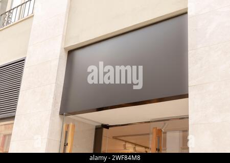 Die elegante, moderne Markise am Schaufensterrand bietet eine perfekte leere Leinwand für den Text oder das Logo eines Unternehmens, ideal für das Markenmarketing. Schwarzes Schild Stockfoto