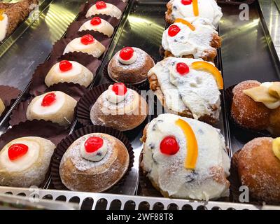 Italienisches, sizilianisches süßes Dessert Cannoli, Konditorei. Sizilien, Italien, serviert eine Person in einer sizilianischen Konditorei traditionelle Ricotta-Cannoli mit candie Stockfoto