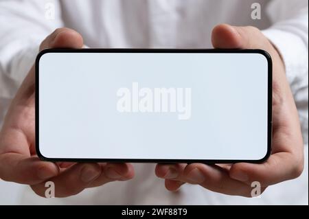 Smartphone mit leerem Bildschirm in zwei Händen Makronahmeansicht Stockfoto