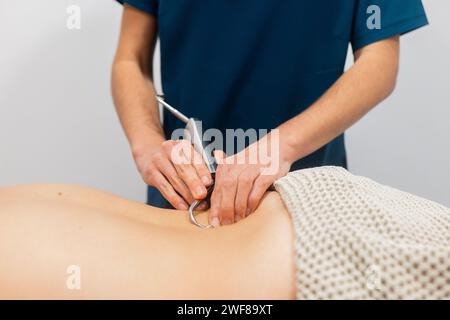 Ein medizinischer Fachmann wird gezeigt, wie er mit einem Ultraschallsensor auf dem Rücken des Patienten physikalische Therapieverfahren demonstriert Stockfoto