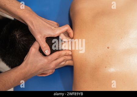 Nahaufnahme einer therapeutischen Massage auf der Schulter einer Person mit Schwerpunkt auf Muskelentlastung Stockfoto
