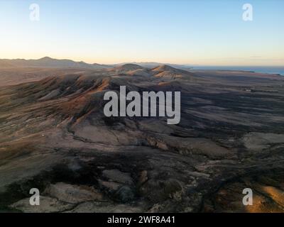 Die Dämmerung durchquert die sanften vulkanischen Hügel nahe der Nordküste von Fuerteventura, die sich von El Cotillo bis Majanicho in der Nähe von Faro del Toston erstrecken Stockfoto