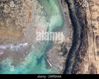 Luftaufnahme von oben auf die flachen Küstengewässer und die zerklüftete Küste an der Nordküste von Fuerteventura, zwischen El Cotillo und Majanicho, in der Nähe Stockfoto