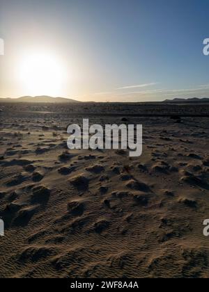 Der Sonnenuntergang wirft lange Schatten über die strukturierte Landschaft der Dünen von Corralejo auf Fuerteventura Stockfoto