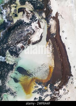 Von oben aus ein Luftbild, das das dramatische Zusammenspiel von vulkanischem Gestein und Gezeitenbecken entlang der Nordküste Fuerteventuras zwischen El Cotillo und Maja einfängt Stockfoto