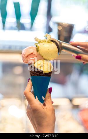 Die Frau hält Eisbecher vor ihr Gesicht, weicher Fokus Stockfoto