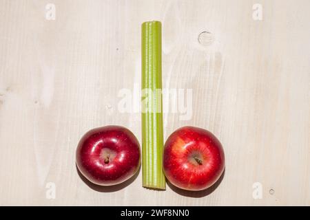 Äpfel und Sellerie auf hölzernem Hintergrund angeordnet Stockfoto