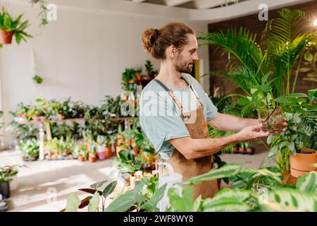 Lächelnder Florist Mann Blumen Verkäufer im Blumenladen, Stockfoto
