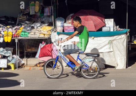 SAMUT PRAKAN, THAILAND, 07. Dezember 2023, Ein Mann fährt auf einem Fahrrad auf dem Marktplatz Stockfoto