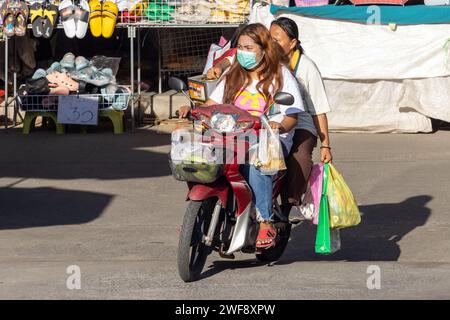 SAMUT PRAKAN, THAILAND, 07. Dezember 2023, zwei Frauen fahren Motorrad mit Einkäufen vom Markt Stockfoto