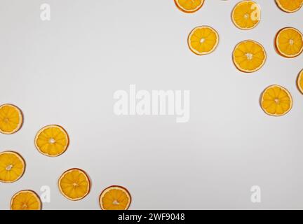 Getrocknete orangefarbene Scheiben auf weißem Hintergrund. Weihnachtskomposition, Neujahr, Winterkonzept. Draufsicht, flach, Kopierbereich. Stockfoto