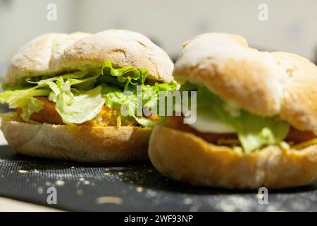 Fisch-Sandwich mit Salat und Ei auf Brötchenbrot. Selektiver Fokus, Nahaufnahme. Stockfoto