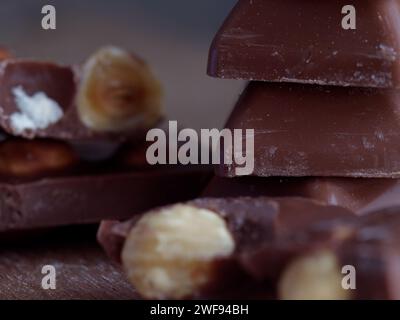 Verschiedene Schokoladenbonbons und Nüsse auf einem rustikalen Holztisch Stockfoto