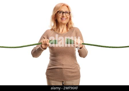 Glückliche, reife Frau, die grüne elektrische Kabel auf weißem Hintergrund anschließt Stockfoto