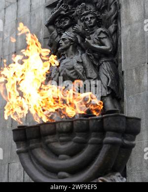 Warschau, Polen, 26. Januar 2024. Eine Menora mit Flammen vor dem Heldendenkmal des Warschauer Ghettos zum Gedenken an den Aufstand des Warschauer Ghettos 1943. Stockfoto