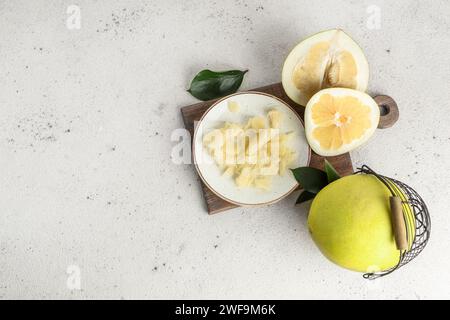 Teller und Korb mit frischen Pomelo-Früchten auf weißem Hintergrund Stockfoto