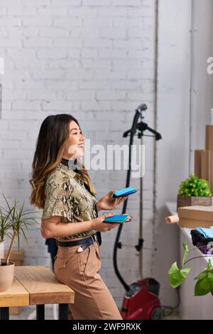 Seitenansicht eines fröhlichen Designers mit Farbmustern im Kleideratelier, privatem Modegeschäft Stockfoto