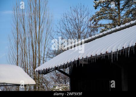 Eiszapfen hängen im Winter vom Dach eines Hauses. Stockfoto