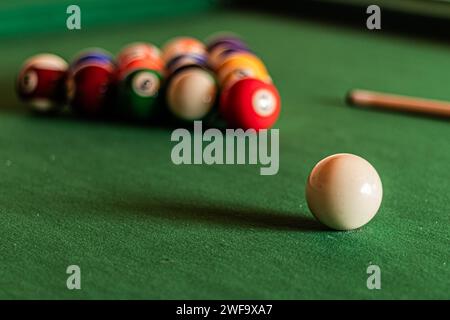 Queuball im Fokus mit Billardbällen in Dreiecksform dahinter Stockfoto