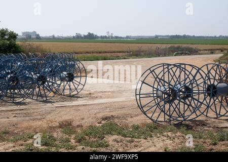 Leere Wasserschlauchspule als Bewässerungsleitung für landwirtschaftliche Felder. Auf den Feldern in Israel. Dieses Wassersystem unterstützt die c Stockfoto